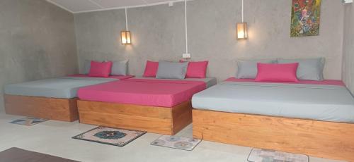 two beds in a room with pink and white sheets at Beach Lovers Tiny House in Nilaveli