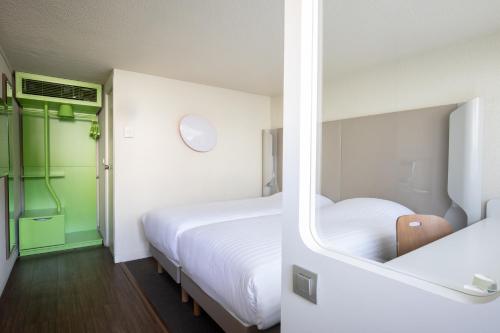 a bedroom with two beds and a green door at Campanile Evry Ouest - Corbeil Essonnes in Corbeil-Essonnes