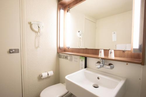 a bathroom with a sink and a toilet and a mirror at Campanile Evry Ouest - Corbeil Essonnes in Corbeil-Essonnes