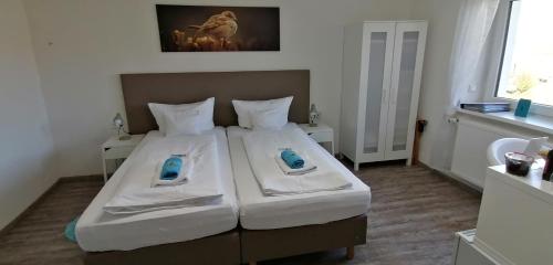 a small bedroom with a bed with two pillows at HOTEL SPATZENNEST Vogelsberg in Herbstein