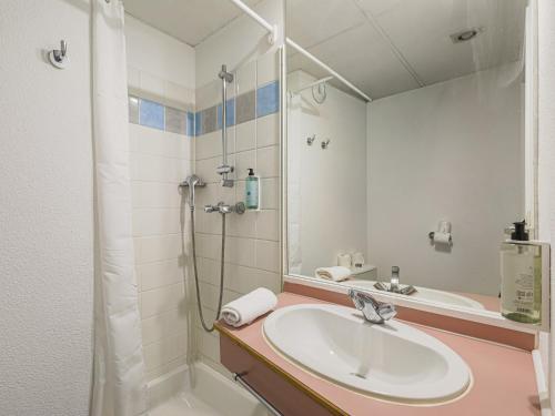 a bathroom with a sink and a shower at Séjours & Affaires Grenoble Marie Curie in Grenoble