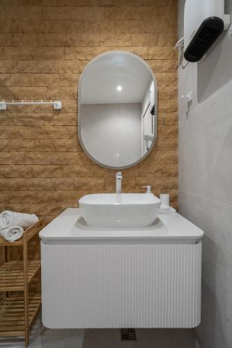 a bathroom with a white sink and a mirror at OLEO hotel in Momchilgrad