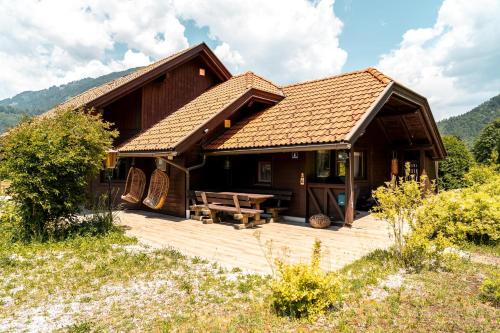 a log cabin with a wooden deck in a field at S´Holzhäusle in Döbriach