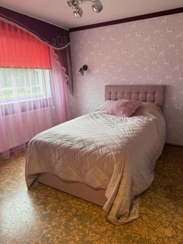 a bedroom with a large bed with pink walls at Aiavilja Red Pearl Apartment in Paide