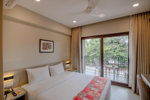 a bedroom with a large bed and a balcony at Comfort Inn Elite in Jua
