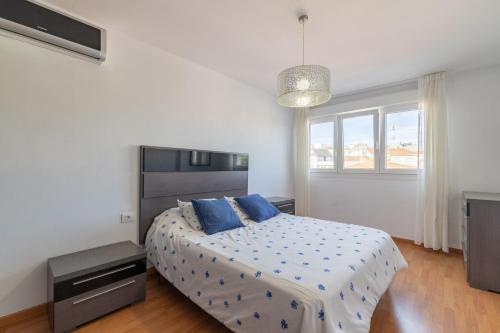 a bedroom with a bed with blue pillows on it at Apartamento familiar acogedor in Ordes