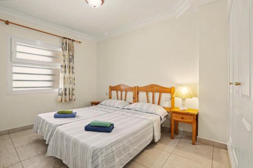 a bedroom with two beds and a table and a window at Los Cristianos Plaza Centre suite in Los Cristianos