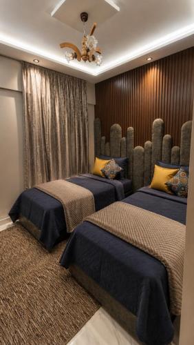 a bedroom with two beds and a chandelier at Lux New Apartment in Mrhila