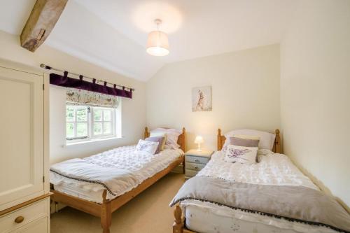 two twin beds in a room with a window at 2 Bed in Upton oc-867 in Upton