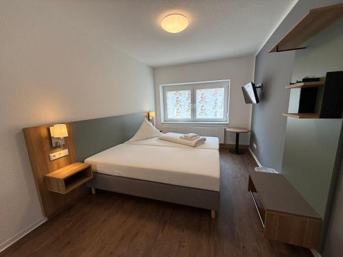 a small bedroom with a bed with a window at Ephesus am Weserwehr in Drakenburg
