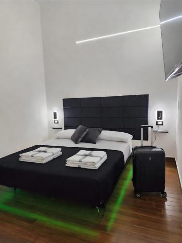 a bedroom with a large bed with a suitcase at Relax Rooms in Trapani