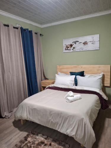a bedroom with a bed with two towels on it at Jacaranda Bnb in Khayelitsha