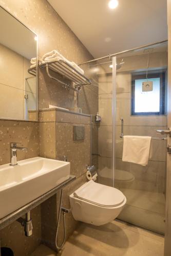 a bathroom with a toilet and a sink and a shower at Comfort Inn Elite in Jua
