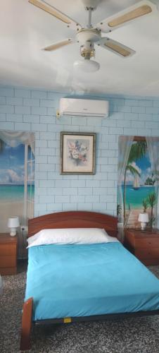 a bedroom with a blue bed and a ceiling fan at Apartamento de 100 M2 con 3 habitaciones y 2 terrazas in El Verger
