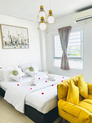 a bedroom with a large bed and a yellow couch at Exclusive Sea View in Chon Buri