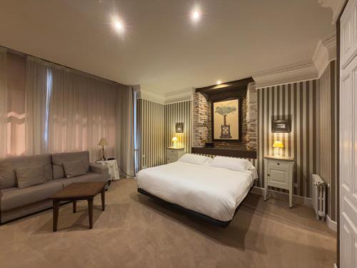 a bedroom with a large bed and a couch at Marina de Campios in Comillas