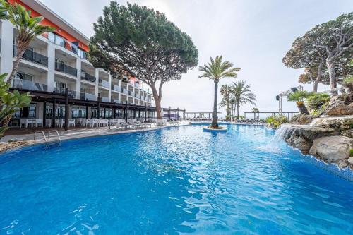an infinity pool at a resort with palm trees at Estival Centurión Playa in Cambrils