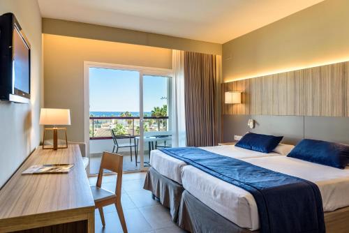 a hotel room with a large bed and a balcony at Estival Park Almaris in La Pineda