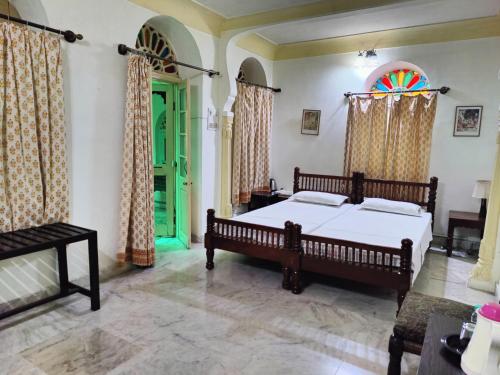 a bedroom with a bed and a stained glass window at Palkiya Haveli - Heritage Hotel in Kota