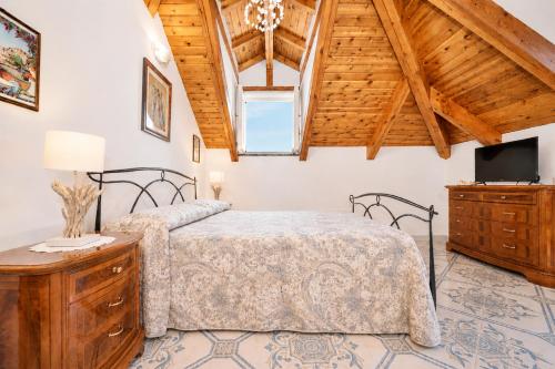 a bedroom with two beds and a tv and a wooden ceiling at Luna Rossa in Minori