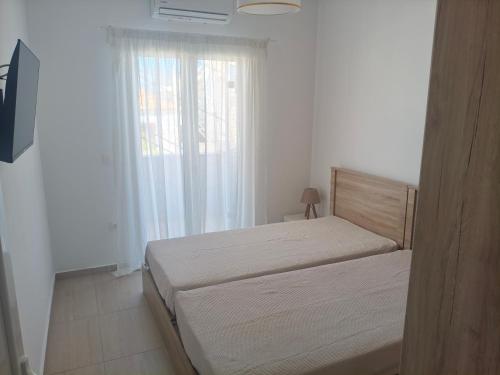 a small bedroom with a bed and a window at Oikonomou Villas 2 in Ermioni
