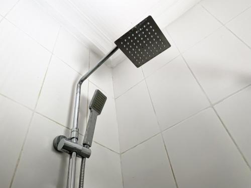 a shower light in a white tiled bathroom at ChallawaRiver Homes in Calabar