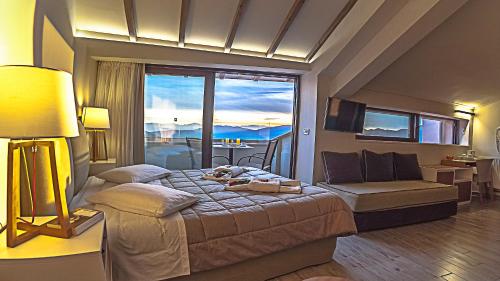 a bedroom with a bed and a large window at Fedriades Delphi Hotel in Delfoi