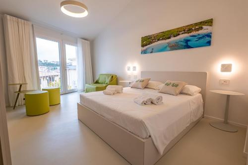 a bedroom with a bed with two towels on it at Marea Boutique Hotel in Orosei