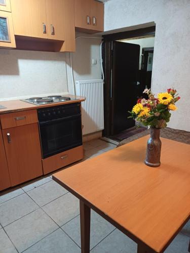 a kitchen with a table with a vase of flowers on it at Кацарила in Gabrovo