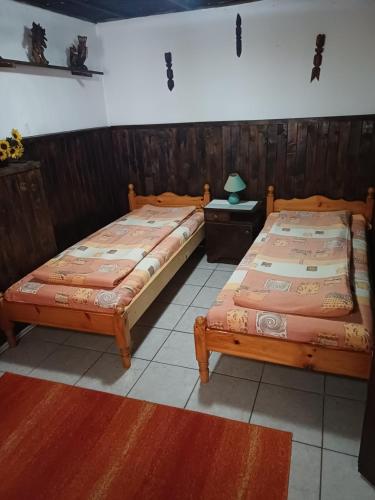 two beds sitting next to each other in a room at Кацарила in Gabrovo