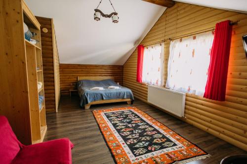 a bedroom with a bed and a rug in a room at Cabana Todireni Vatra Dornei in Vatra Dornei