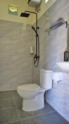 a bathroom with a toilet and a sink at Kubu Kiku Megati in Selemadeg