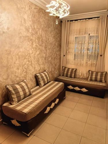 a living room with two benches and a window at Skikda in Cité el ʼArbi Ben Mhîdi