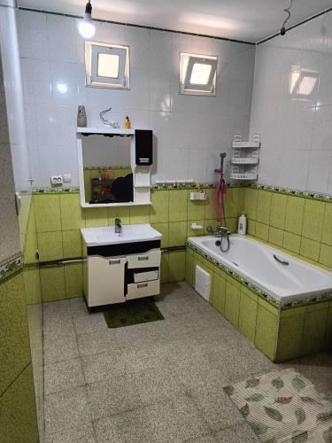 a bathroom with a tub and a sink and a mirror at Skikda in Cité el ʼArbi Ben Mhîdi