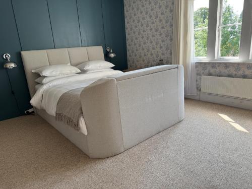 a large bed in a bedroom with blue walls at Whichcote Arms Hotel in Sleaford