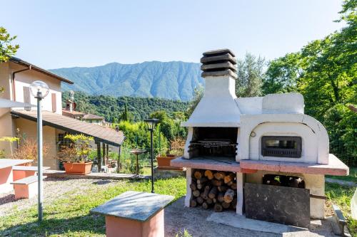 a outdoor oven with a pile of fire wood at Ina's Lake Garden, Como Lake in Lenno
