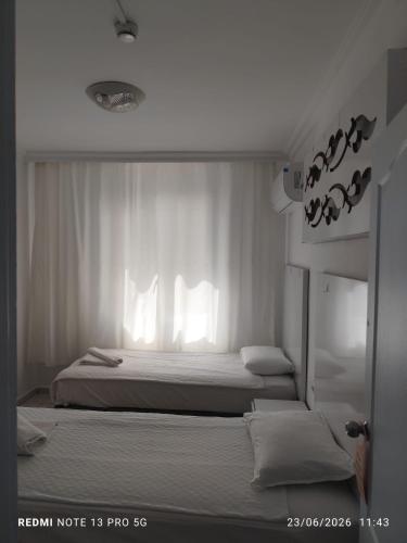 two beds in a room with white walls and windows at Blue Garden Family Side in Side