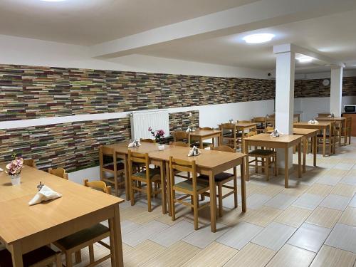 a restaurant with wooden tables and chairs and a brick wall at Easy Star Hotel in Budapest