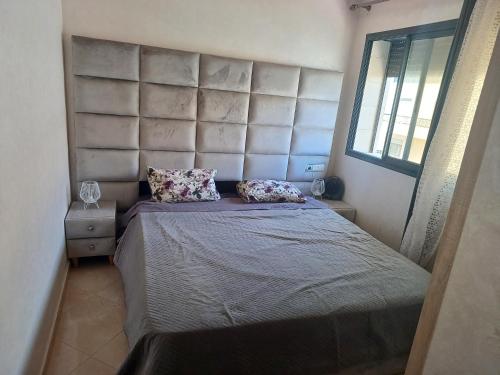 a bedroom with a large bed with a large headboard at الشروق 2 résidence chourouk 2 in Mansouria