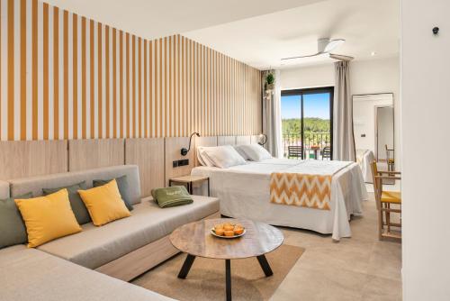 a hotel room with a bed and a couch at Tangerine by Honne Hotels - Adults Only in Magaluf