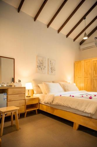 a bedroom with a bed and a dresser and a mirror at Kondey Villas in Kondey
