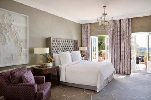 a bedroom with a white bed and a chair at Four Seasons Hotel The Westcliff in Johannesburg
