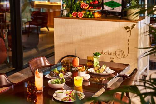 a table with plates of food and drinks on it at The Emory, Maybourne in London