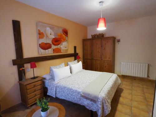 a bedroom with a bed and a dresser in it at La Senda Del Duratón in Sebúlcor