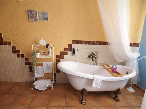 a bath tub in a bathroom with a curtain at La Senda Del Duratón in Sebúlcor