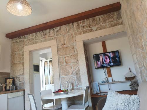 a kitchen and dining room with a stone wall at Apartment Nada in Rogoznica