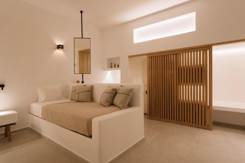 a white bedroom with a bed and a window at Ios Sea view apartment with pool 2B in Ios Chora