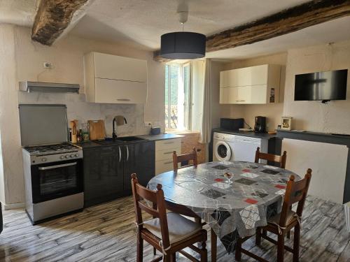 a kitchen with a table and chairs in a room at Le papey in Molières-Cavaillac