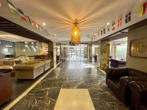 a large living room with couches and a chandelier at Elite Hotel Airport in Dhaka