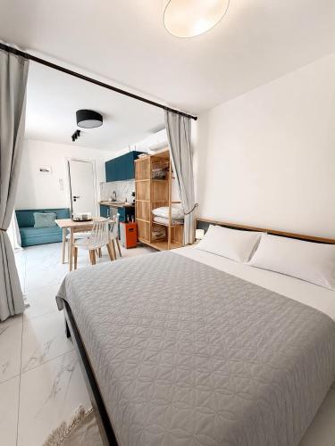 a bedroom with a large bed and a table at Grand Relax Suites in Diakopto